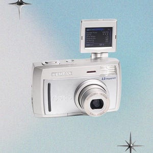 May include: Silver Pentax Optio digital camera with a 3.2 Megapixels lens. The camera has a small screen on top and a lens that reads 5.8mm-17.4mm. The background is a gradient of blue and white with star-shaped accents.