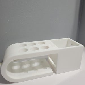 May include: A set of three ceramic mugs with a speckled, matte finish. The mugs are in shades of cream, light gray, and dark gray. Each mug has a simple, minimalist design and a rounded handle. The mugs are stacked on top of each other.