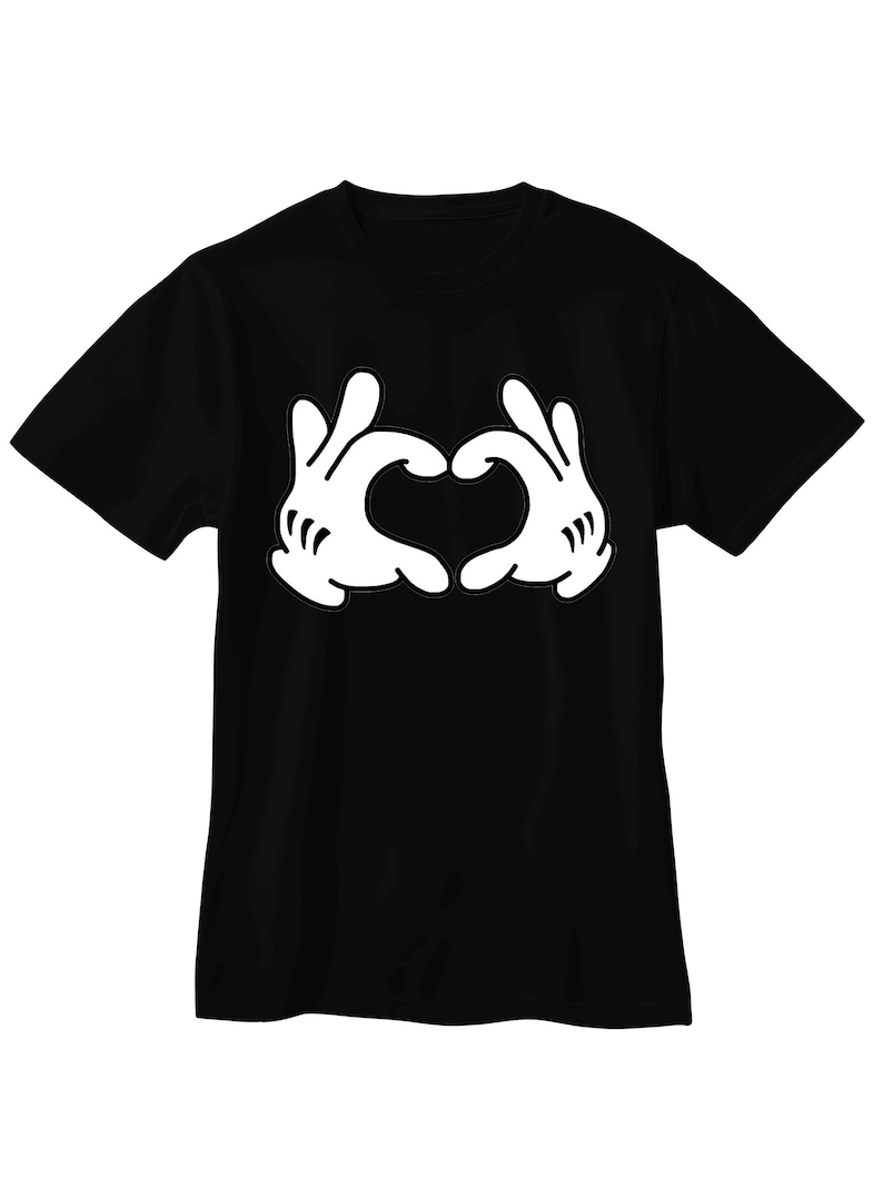 May include: A black short-sleeved t-shirt featuring a large white graphic print on the chest. The graphic depicts two cartoon-style gloved hands positioned together to form a heart shape, with three distinct lines on each glove wrist.
