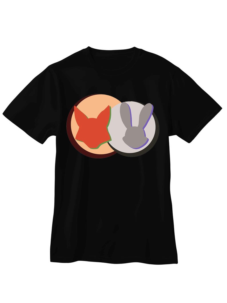 May include: A black short-sleeved t-shirt featuring a graphic design on the chest. The design consists of two overlapping circles, one orange and one light gray, containing the silhouettes of a fox head and a rabbit head respectively.