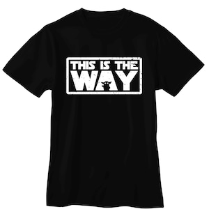Pu&ograve; includere: T-shirt nera con grafica rettangolare bianca. La grafica recita "THIS IS THE WAY" in maiuscolo, con una silhouette di personaggio sotto la parola "WAY".