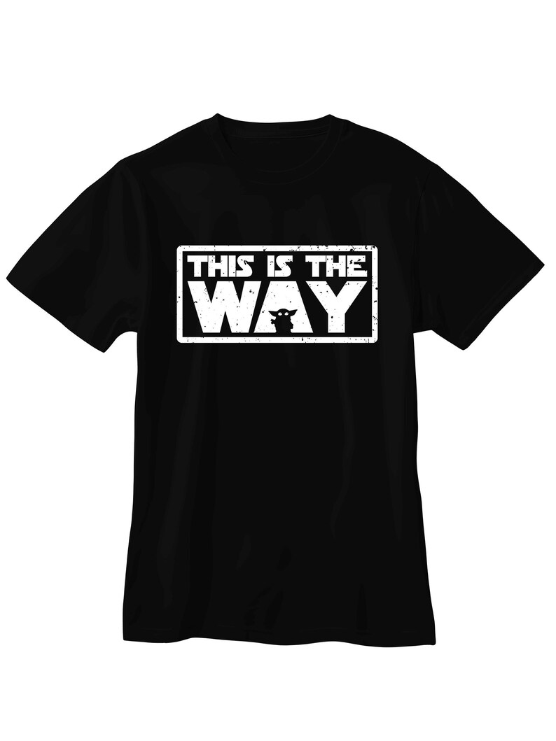 Pu&ograve; includere: T-shirt nera con grafica rettangolare bianca. La grafica recita "THIS IS THE WAY" in maiuscolo, con una silhouette di personaggio sotto la parola "WAY".
