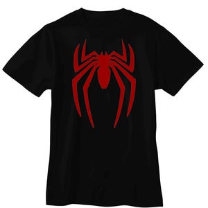 May include: A black short-sleeved t-shirt featuring a large, centered red spider graphic on the chest. The spider design has elongated, pointed legs and a solid red body, contrasting sharply against the plain black fabric of the garment.