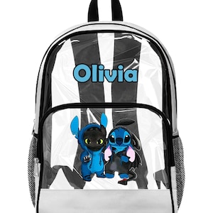Puede incluir: Una mochila transparente con un dise&ntilde;o de rayas blancas y negras. La mochila presenta el nombre "Olivia" en letras azules y un gr&aacute;fico de dos personajes de dibujos animados. Tiene un asa negra y bolsillos laterales de malla.