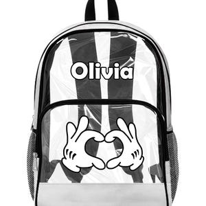 Peut inclure: Sac &agrave; dos transparent avec int&eacute;rieur &agrave; rayures noires et blanches. Comporte le nom "Olivia" en lettres blanches et un c&oelig;ur fait de mains de dessins anim&eacute;s blanches. Avec garniture noire et base blanche.