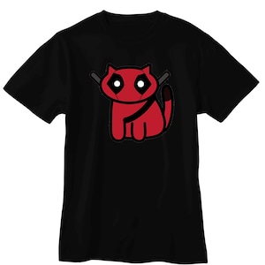 Może przedstawiać: Czarny t-shirt z czerwonym rysunkiem kota. Kot ma białe oczy, czarny pas i dwa szare miecze za głową. Projekt jest zabawną wersją popularnej postaci. Koszulka wykonana jest z miękkiego materiału.