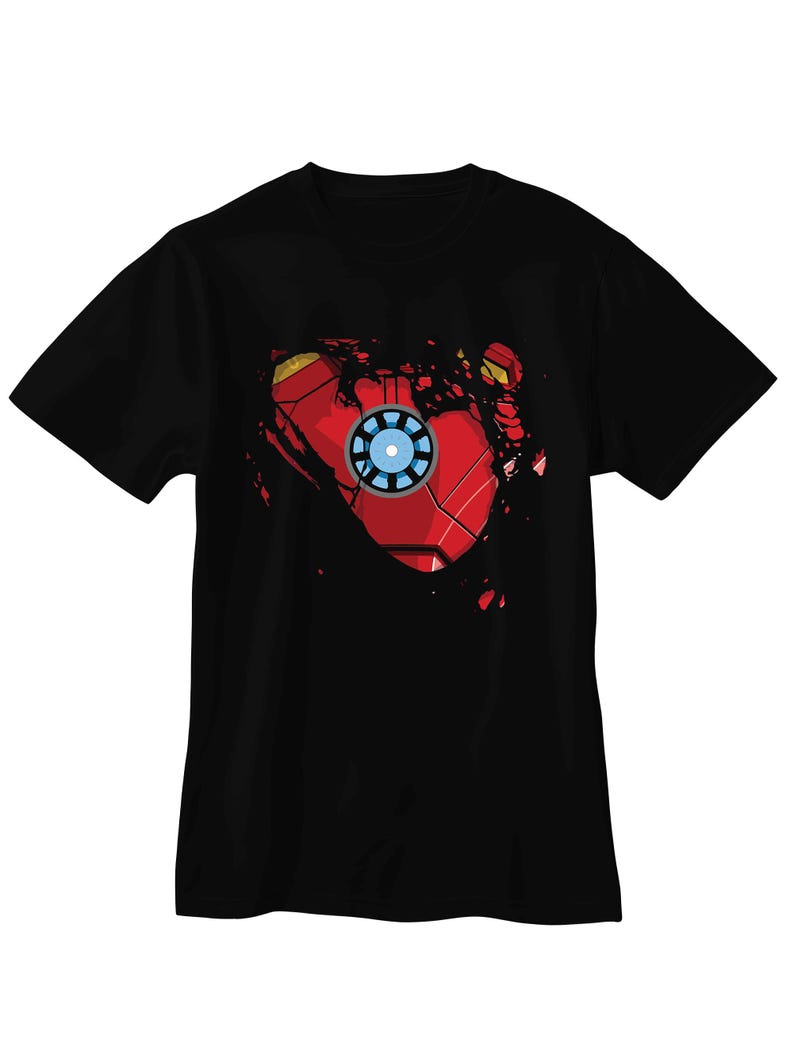 May include: Black t-shirt featuring a graphic design of Iron Man's arc reactor and chest armor. The design is red, gold, and blue, with a distressed, torn effect. The shirt is a short-sleeved crew neck.