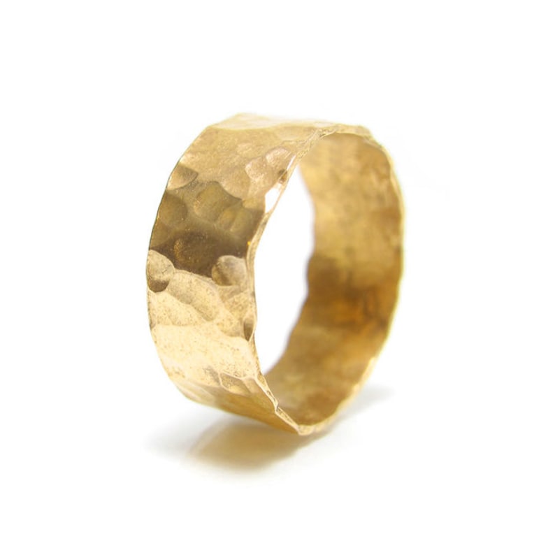 May include: A gold hammered ring with a wide band.