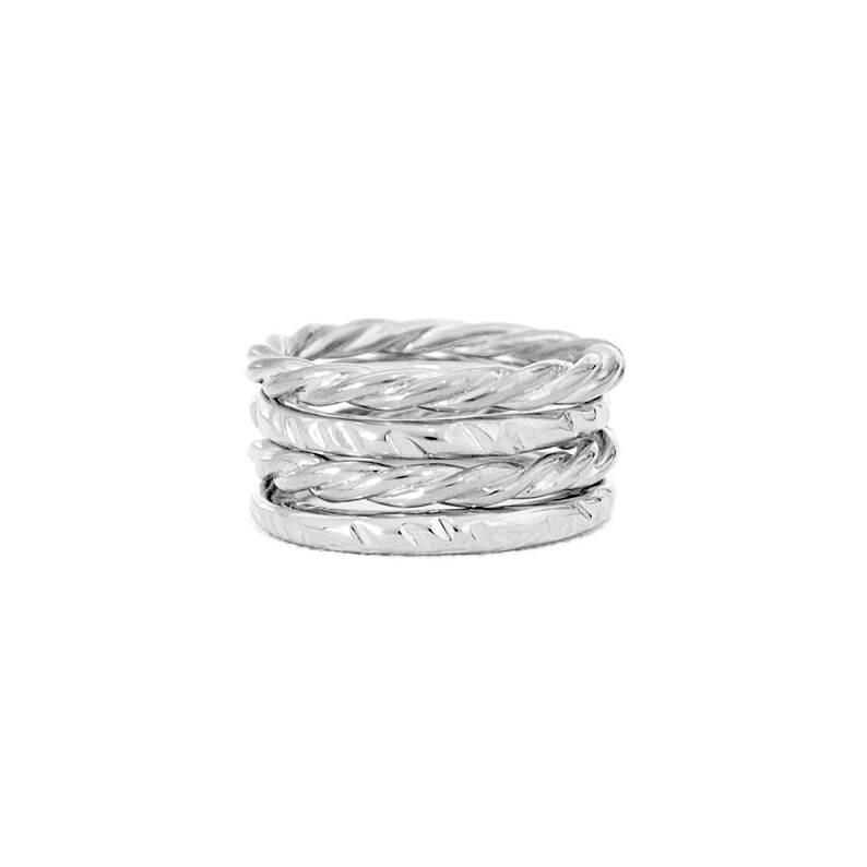May include: A set of five silver rings stacked together. Each ring has a twisted, textured design.