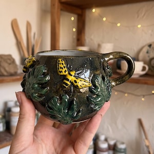 Tazza in ceramica fatta a mano con ape, tazza botanica realizzata al tornio, design naturalistico con foglie verdi, regalo unico per caffè e tè.