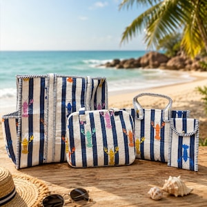May include: A collection of striped tote bags, a handbag, and a small pouch, all featuring a navy blue and white striped pattern with colorful lobster illustrations. The bags are arranged on a wooden surface with a beach backdrop.