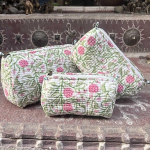 Pode incluir: Tr&ecirc;s bolsas acolchoadas com fecho de correr de tamanhos variados, com uma base branca e um padr&atilde;o repetitivo de videiras verdes e flores cor-de-rosa. Cada bolsa possui um fecho de correr branco na borda superior e acabamento texturizado.