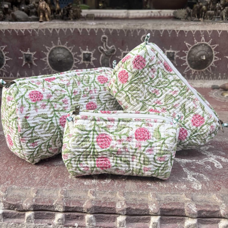 Pode incluir: Tr&ecirc;s bolsas acolchoadas com fecho de correr de tamanhos variados, com uma base branca e um padr&atilde;o repetitivo de videiras verdes e flores cor-de-rosa. Cada bolsa possui um fecho de correr branco na borda superior e acabamento texturizado.