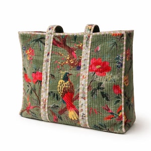 May include: Green tote bag with a vibrant floral and bird pattern. The bag features a quilted texture and sturdy handles. The design includes red flowers, yellow and red birds, and a mix of other colorful elements.