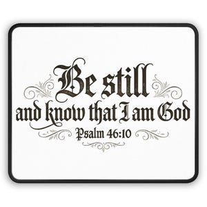 Puede incluir: Alfombrilla de ratón rectangular blanca con un borde cosido negro. La alfombrilla muestra el texto "Be still and know that I am God Psalm 46:10" en una fuente decorativa con detalles florales.