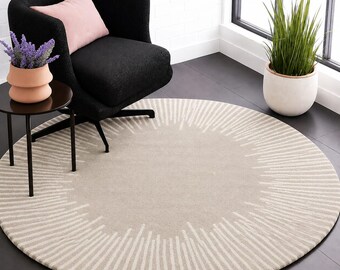 May include: A round area rug featuring a beige centre and a radiating sunburst pattern in cream. The design consists of varying lengths of vertical lines extending outward from the solid circular core, creating a textured visual effect on the floor.