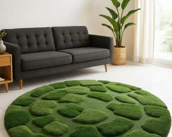 May include: A circular area rug featuring a textured, moss-like surface with raised, irregular green shapes that mimic the appearance of stones or pebbles. The rug has a deep forest green colour and a soft, plush pile that creates a dimensional effect.