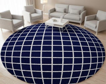 May include: A large circular area rug featuring a deep navy blue background with a crisp white grid pattern. The rug has a textured, soft pile surface and is positioned centrally on a light-coloured wooden floor in a living room setting.