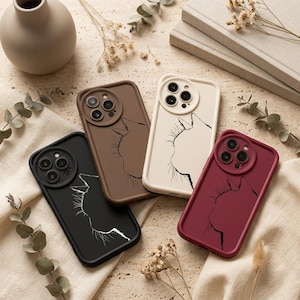 May include: Four rectangular smartphone cases featuring a minimalist line art profile of a cat head. The cases are available in black, brown, cream, and deep red, each with a circular camera cutout and a contrasting outline of a feline face.