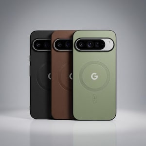 Op de afbeelding: Drie smartphonehoesjes in zwart, bruin en saliegroen. Elk hoesje heeft een horizontale camerabalk aan de bovenkant, een cirkelvormige magnetische oplaadring in het midden, een Google G-logo en een klein bliksemschichtpictogram onderaan.