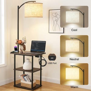May include: A black floor lamp with a brown table and shelves. The lamp has a beige lampshade and a curved arm. The table has a laptop, a USB port, and decorative items. The lamp offers cool, neutral, and warm light settings.