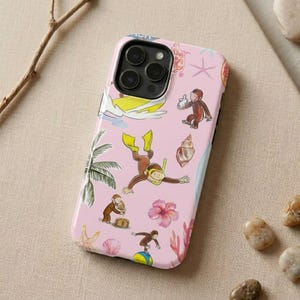 May include: Pink phone case featuring illustrations of a monkey in various beach activities, including surfing, snorkeling, and balancing on a ball. Other illustrations include a palm tree, starfish, and a seashell.