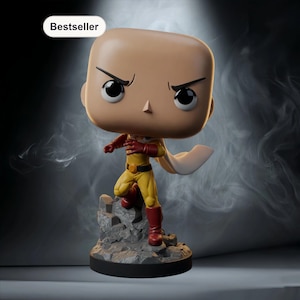 Puede incluir: Figura de vinilo del personaje Saitama de la serie de anime One-Punch Man. La figura está en una pose dinámica, con un mono amarillo, guantes y botas rojas y una capa blanca. La figura está sobre una base rocosa y tiene la palabra "Bestseller".