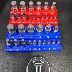 May include: A set of hex bit sockets and drivers in red and blue organizers. The sockets are various sizes, labeled with inch measurements. A black and white Atlas Works Co. logo is at the bottom.