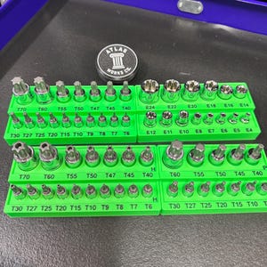 May include: A set of green socket organizers filled with various sizes of torx and external torx bits. The bits are labeled with sizes like T70, T60, T55, and E24. A metal Atlas Works Co. emblem is also visible.
