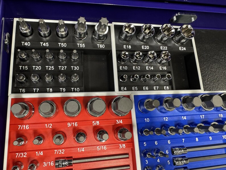 May include: A set of various metal sockets and bits, organized in a blue and red tray. The set includes different sizes and types of sockets, with labels such as T40, T45, T50, and E18, E20, E22.