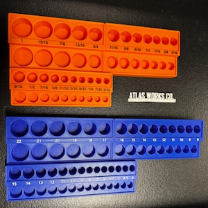 May include: Orange and blue socket organisers with various sized circular openings. The orange organisers have measurements in inches, while the blue organisers have numbered sizes. The text "ATLAS WORKS CO" is visible.