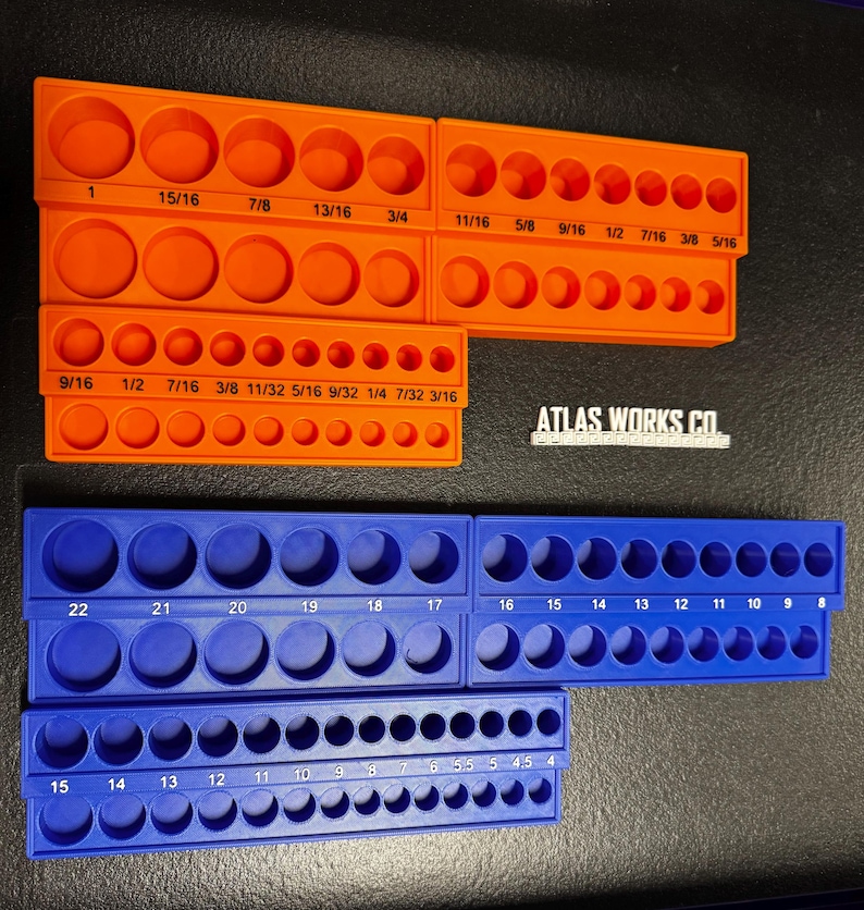 May include: Orange and blue socket organisers with various sized circular openings. The orange organisers have measurements in inches, while the blue organisers have numbered sizes. The text "ATLAS WORKS CO" is visible.