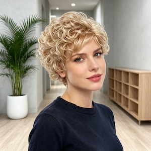 May include: A short, curly blonde wig with layered, voluminous ringlets. The hair features a mix of light golden and platinum blonde tones, styled in a textured, cropped cut that frames the face with soft, defined curls throughout the crown.