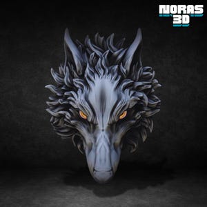 Puede incluir: Una detallada escultura de cabeza de lobo en escala de grises con ojos de color naranja fuego. La escultura tiene intrincados detalles de pelaje y está sobre un fondo oscuro. El texto "NORAS 3D" está en la esquina superior derecha.