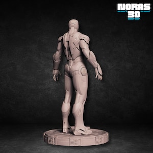 May include: A 3D-printed figure of a futuristic armored suit, viewed from the back. The figure is light gray and stands on a circular base with a detailed design. The image includes the text "NORAS 3D" in a teal font.