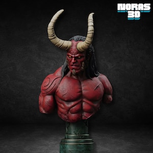 Può includere: Busto rosso di un demone muscoloso con grandi corna e un'espressione severa. La figura ha lunghi capelli neri, un pizzetto e un tatuaggio sul braccio sinistro. Il busto è montato su un piedistallo verde e usurato. Il testo "NORAS 3D" è in alto a destra.