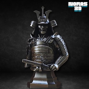 May include: A detailed, metallic bust of a samurai warrior, complete with helmet, armor, and a katana. The figure is dark gray with intricate detailing, and the image includes the text "NORAS 3D" in a stylized font.