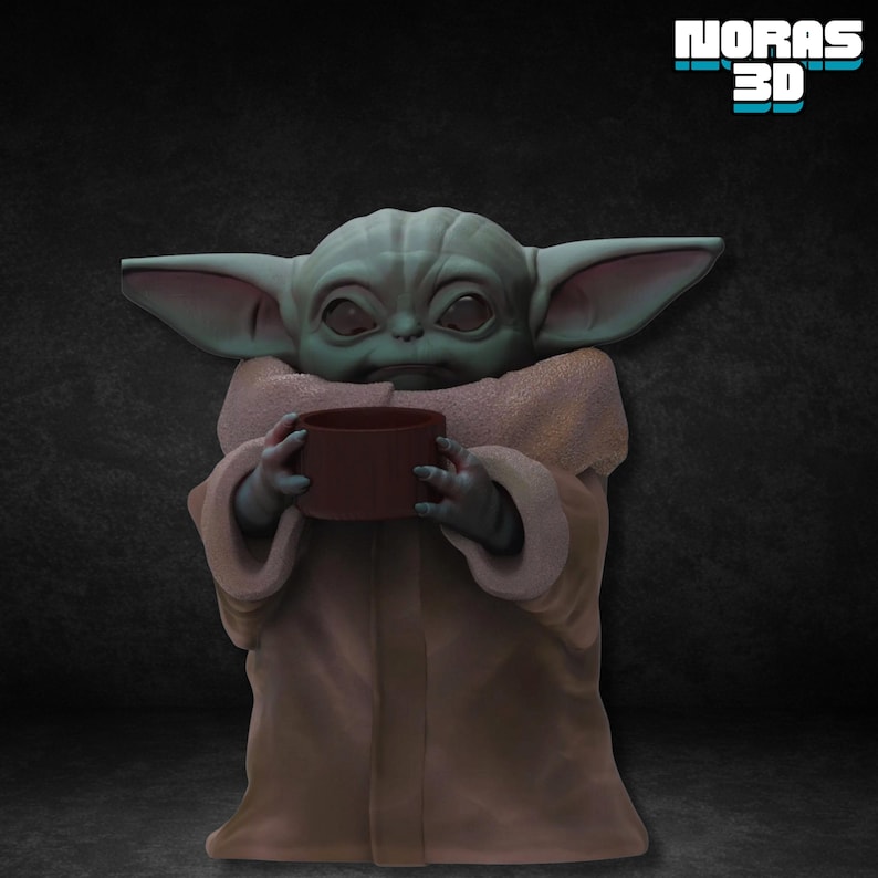 Pode incluir: Figura impressa em 3D de um alien&iacute;gena de pele verde segurando uma x&iacute;cara marrom. A figura tem orelhas grandes e est&aacute; vestindo uma t&uacute;nica bege. O texto "NORAS 3D" est&aacute; no canto superior direito.