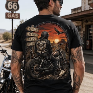 May include: A black t-shirt featuring a graphic print of a motorcyclist on a bike in a desert landscape at sunset. The design includes text reading NO PLAN, NO MAP, NO GPS, JUST RIDE, and RIDE MORE WORRY LESS, along with a skull and eagle illustration.