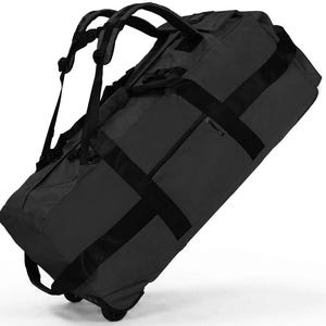 May include: A large charcoal gray rolling duffel bag featuring black webbing straps, a retractable handle, and two wheels at the base. The bag includes multiple exterior zippered compartments and adjustable backpack-style shoulder straps.