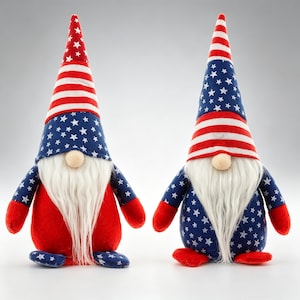 May include: Two patriotic gnomes with long white beards and red, white, and blue outfits. One gnome has a red and white striped hat, while the other has a blue hat with white stars. Both have red hands and feet.