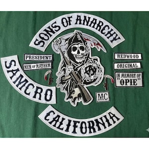 May include: A collection of embroidered patches with a biker theme. The central patch features a grim reaper holding a rifle. Other patches include the words "Sons of Anarchy", "Samcro", "California", and smaller patches with text like "President" and "Redwood".