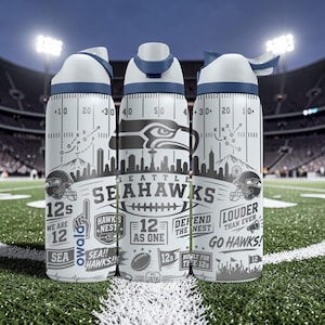 Puede incluir: Una botella de agua Owala blanca con gráficos de los Seattle Seahawks, incluyendo el logo del equipo, un diseño de campo de fútbol americano, y el texto 'Seattle Seahawks', '12s', 'We Are 12', 'Defend The Nest', 'Louder Than Ever' y 'Go Hawks!'.