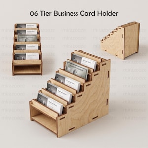 May include: A light-colored wooden 06 Tier Business Card Holder with six stepped slots for displaying cards. The structure features visible joinery and a tiered design, shown from both a front-facing perspective and a side angle view.