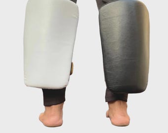 Protector de pantorrillas – Piel de búfalo, ideal para MMA, Muay Thai y Kickboxing. Escudo de golpeo resistente.