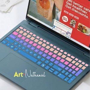 Może przedstawiać: Ciemnoniebieski laptop z gradientową nakładką na klawiaturę przechodzącą od różu przez fiolet do niebieskiego. Ekran wyświetla stronę internetową z tekstem Get better eats. Get healthier. Get discounts. Logo Art Nathaniel znajduje się na podkładce.