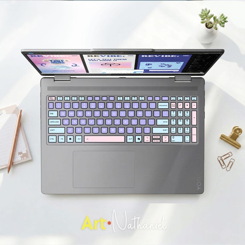 K&ouml;nnte beinhalten: Ein grauer Laptop mit einer individuellen Tastaturfolie in Pastellfarben, bestehend aus hellvioletten, hellblauen und zartrosa Tasten. Der Bildschirm zeigt eine digitale Benutzeroberfl&auml;che mit dem Text REVIBE und LET'S TELL THEM YOU HAVE IT.