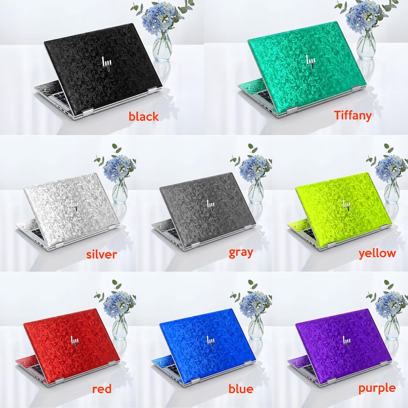 Op de afbeelding: Een collectie van acht laptopskins met een textuur van gekreukt fluweel in zwart, Tiffany-blauw, zilver, grijs, geel, rood, blauw en paars. Elke skin toont een centraal logo en is aangebracht op een laptop.
