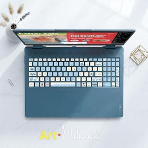 May include: A blue laptop featuring a custom keyboard skin with light blue and white keys, decorated with small candy and snowflake icons. The screen displays a website with the text better eats and get better eats. Get healthier.
