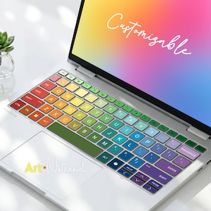 May include: A laptop featuring a rainbow keyboard cover. The keys are in a QWERTY layout, each a different colour. The screen shows the word "Customizable" in white script. The laptop is white.